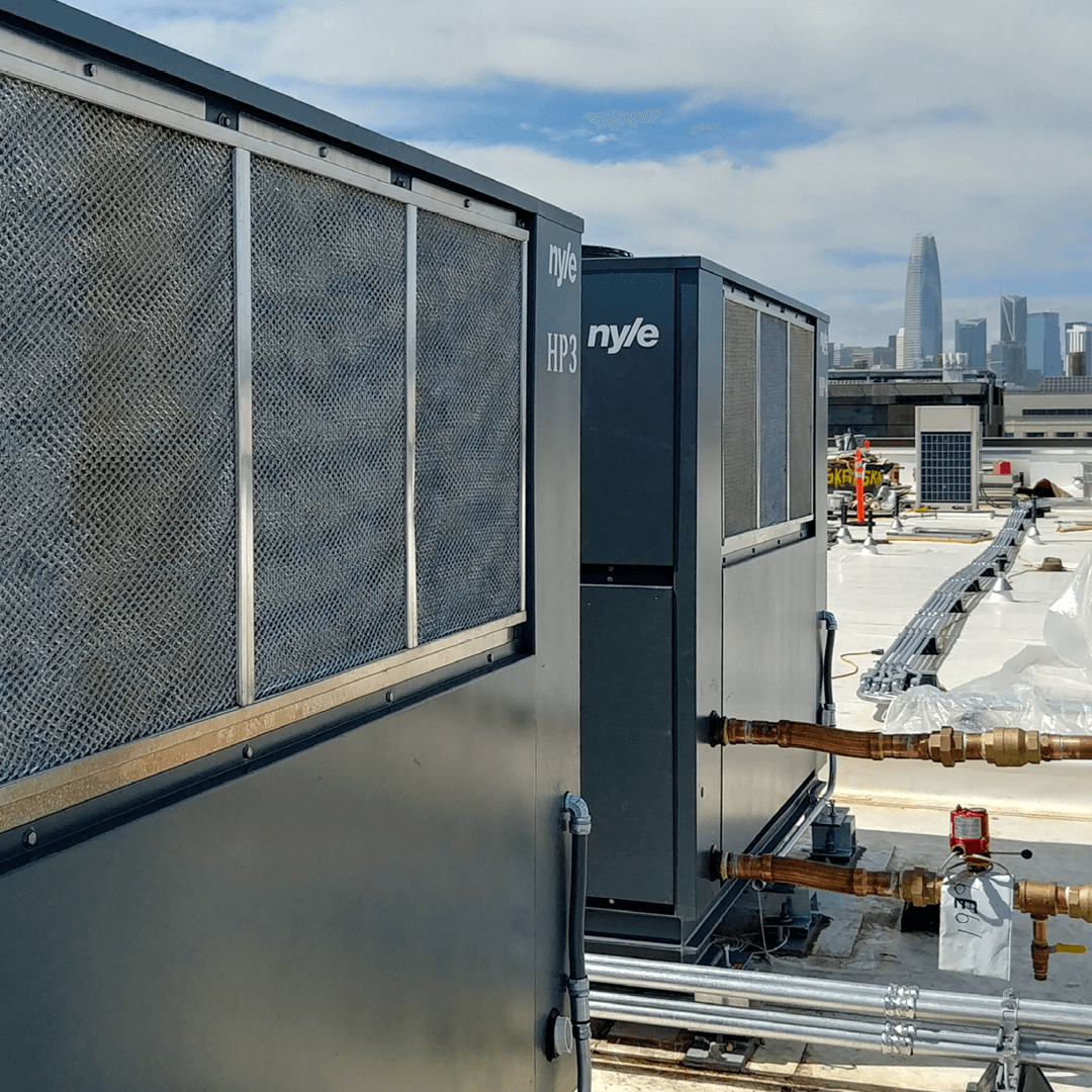 Photo of Nyle heat pump water heaters on the rooftop of a large building